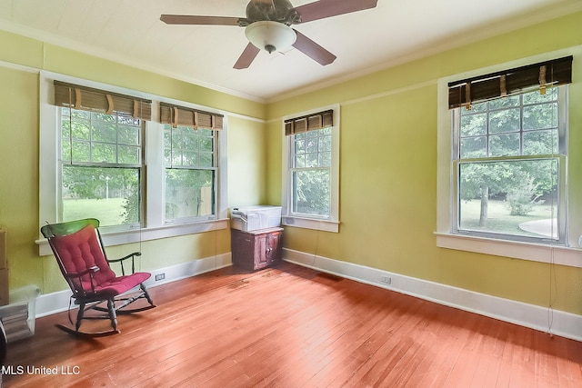 sitting room with a ceiling fan, crown molding, baseboards, and hardwood / wood-style flooring