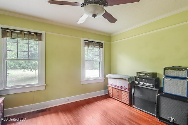 interior space with baseboards, visible vents, ornamental molding, and wood finished floors