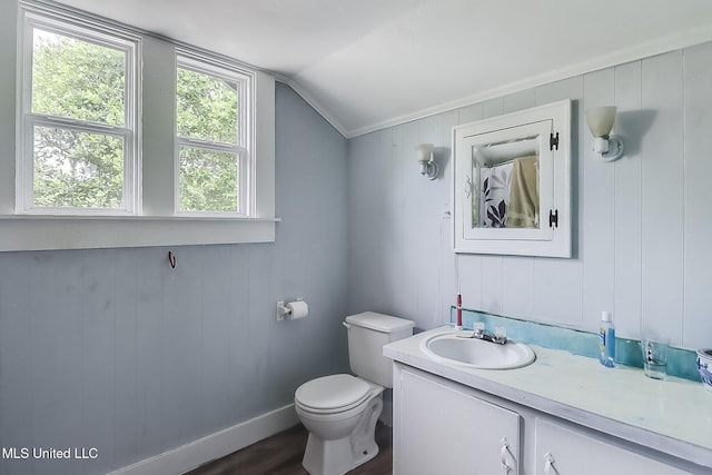 full bath with toilet, vaulted ceiling, vanity, wood finished floors, and baseboards