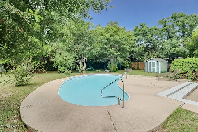 pool featuring an outbuilding, fence, a yard, a shed, and a patio area