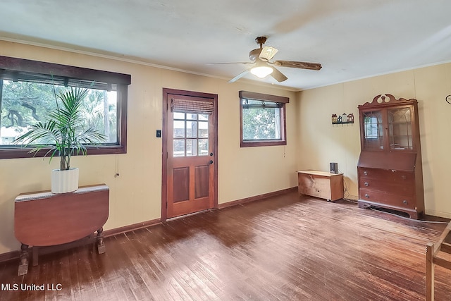 entryway featuring ornamental molding, ceiling fan, baseboards, and wood finished floors