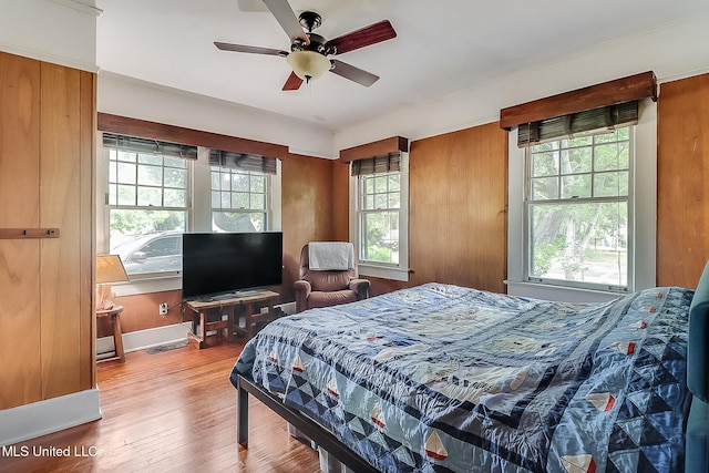 bedroom with ceiling fan, baseboards, and wood finished floors