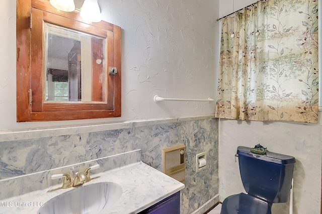 bathroom with a wainscoted wall and vanity