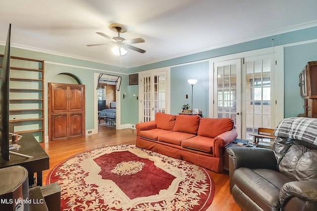 living room with crown molding, wood finished floors, and french doors