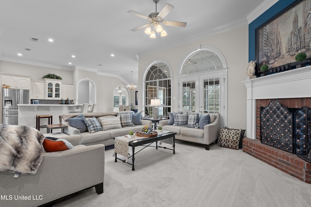 carpeted living room with crown molding, french doors, and ceiling fan with notable chandelier