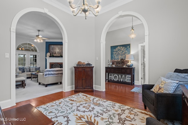 interior space with hardwood / wood-style floors, ceiling fan with notable chandelier, and crown molding