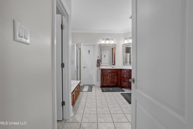 bathroom with tile patterned flooring, vanity, a shower with shower door, and crown molding