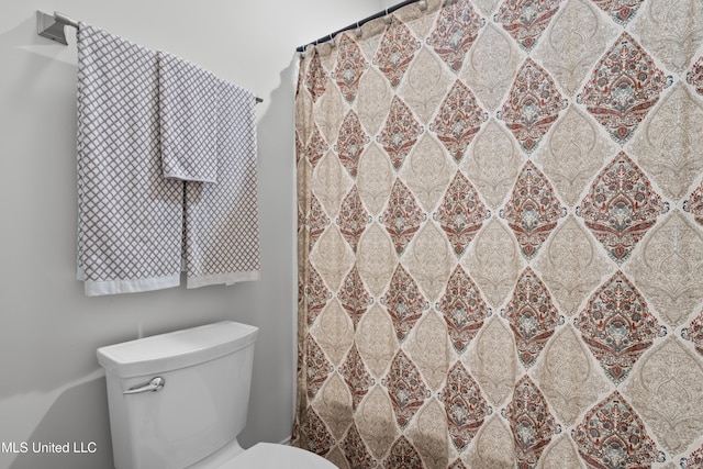 bathroom featuring toilet and walk in shower