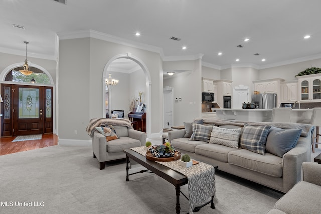 living room featuring a chandelier, light wood-type flooring, and ornamental molding