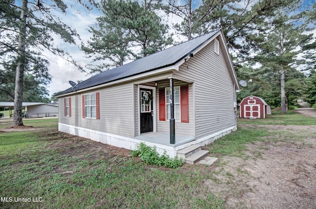 8962 Pleasant Hill Rd, Carthage, MS 39051 - view of home's exterior with metal roof, covered porch, solar panels, and a lawn