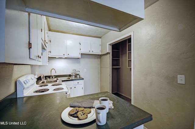 8962 Pleasant Hill Rd, Carthage, MS 39051 - kitchen with electric stove, dark countertops, a peninsula, a textured wall, and a sink