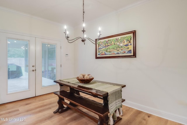 6811 Old Fort Bayou Rd, Ocean Springs, MS 39564 - dining room featuring french doors, a chandelier, crown molding, and light wood-type flooring