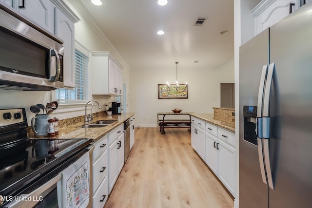 6811 Old Fort Bayou Rd, Ocean Springs, MS 39564 - kitchen with stainless steel appliances, a sink, light wood-style floors, recessed lighting, and white cabinets