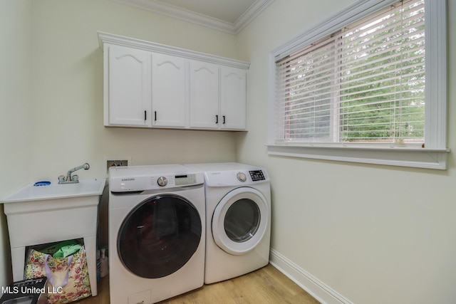 6811 Old Fort Bayou Rd, Ocean Springs, MS 39564 - washroom with cabinet space, washing machine and clothes dryer, ornamental molding, baseboards, and light wood-type flooring