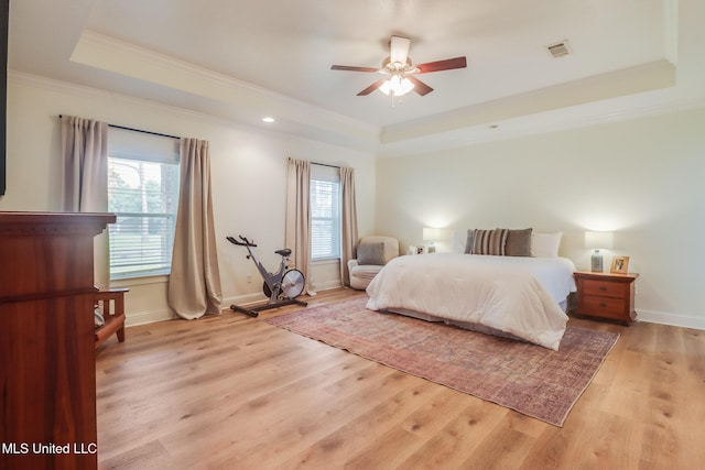 6811 Old Fort Bayou Rd, Ocean Springs, MS 39564 - bedroom with a tray ceiling, crown molding, light wood-style flooring, baseboards, and ceiling fan
