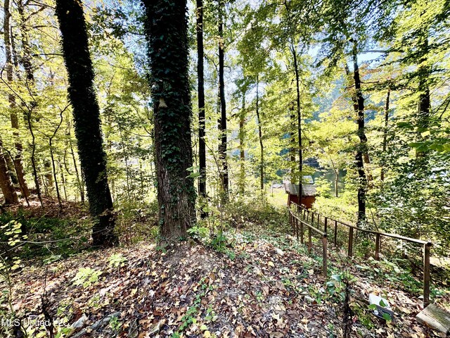 view of yard featuring fence and a wooded view