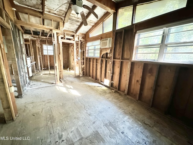 misc room with a ceiling fan, an AC wall unit, and vaulted ceiling