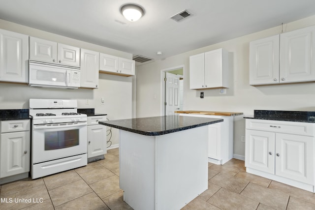 kitchen featuring visible vents, white cabinets, and white appliances