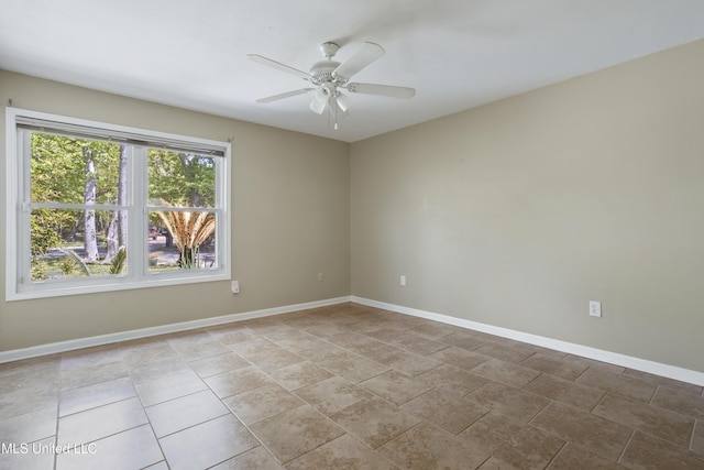 empty room featuring a ceiling fan and baseboards