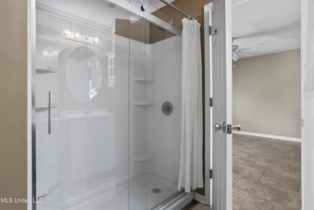 full bathroom featuring baseboards, a ceiling fan, and a stall shower