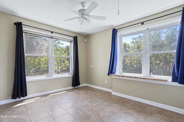 spare room with baseboards, plenty of natural light, and a ceiling fan