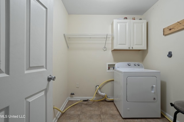 laundry area featuring light tile patterned floors, baseboards, cabinet space, and washer / clothes dryer