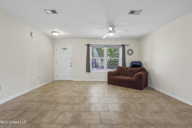 living area featuring a ceiling fan, baseboards, and visible vents