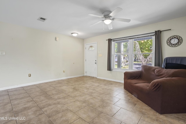 living area with visible vents, baseboards, ceiling fan, and light tile patterned flooring