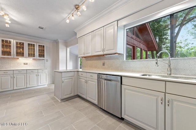 kitchen with white cabinetry, backsplash, sink, and stainless steel dishwasher