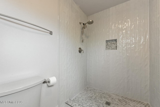 bathroom featuring toilet and tiled shower