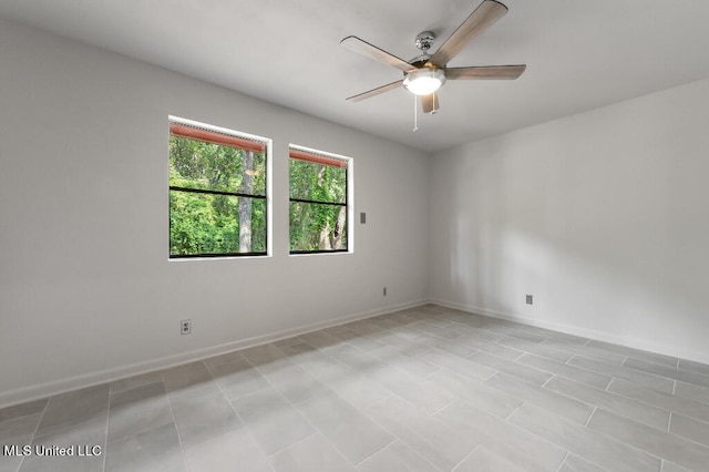 empty room with light tile patterned floors and ceiling fan