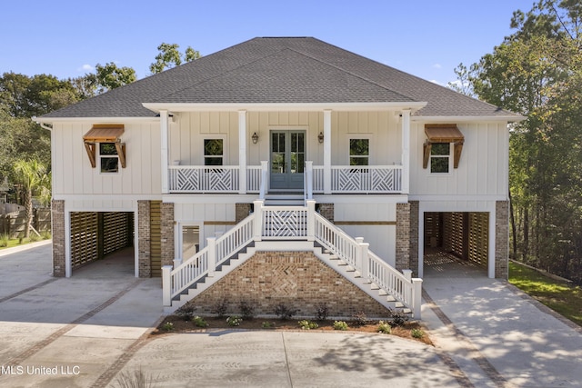beach home featuring driveway, a porch, a shingled roof, and a carport