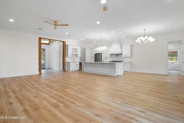 unfurnished living room with light hardwood / wood-style floors, ornamental molding, sink, and ceiling fan with notable chandelier