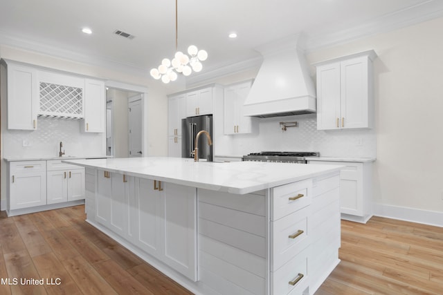 kitchen featuring white cabinets, custom range hood, and light wood-type flooring