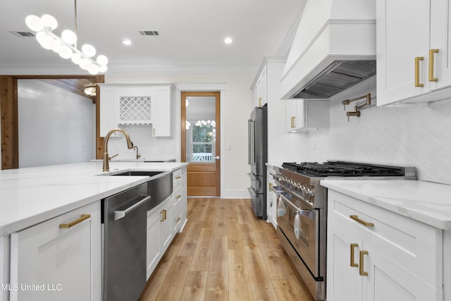 kitchen with visible vents, custom range hood, white cabinetry, high end appliances, and decorative backsplash