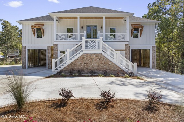 coastal inspired home featuring a porch, roof with shingles, french doors, stairway, and a carport