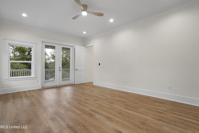 empty room with crown molding, light wood-type flooring, baseboards, and a ceiling fan