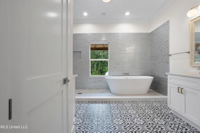 bathroom with vanity, a bathing tub, tile patterned floors, and tile walls