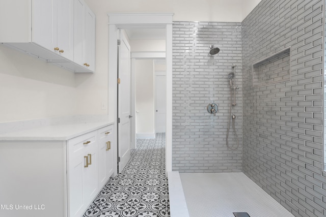 bathroom featuring tile patterned flooring and tiled shower