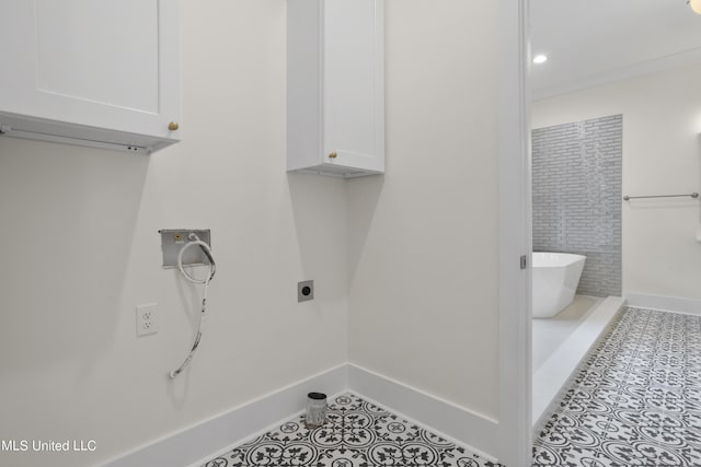 laundry area featuring cabinet space, hookup for an electric dryer, tile patterned flooring, baseboards, and hookup for a washing machine