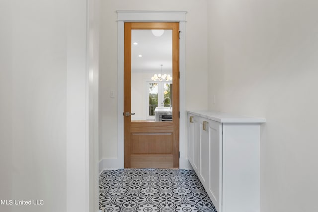 doorway to outside with a chandelier and light tile patterned floors