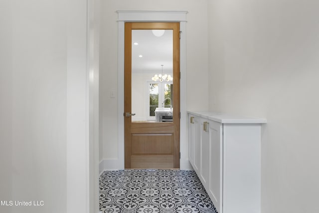 entryway with a chandelier and baseboards
