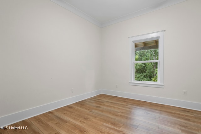 spare room with crown molding and light wood-type flooring