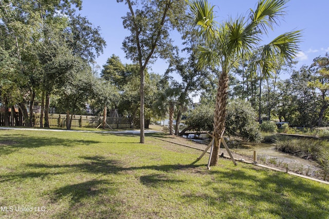 view of home's community featuring a yard and fence