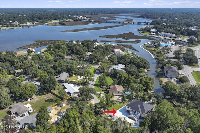 drone / aerial view with a water view, a residential view, and a view of trees