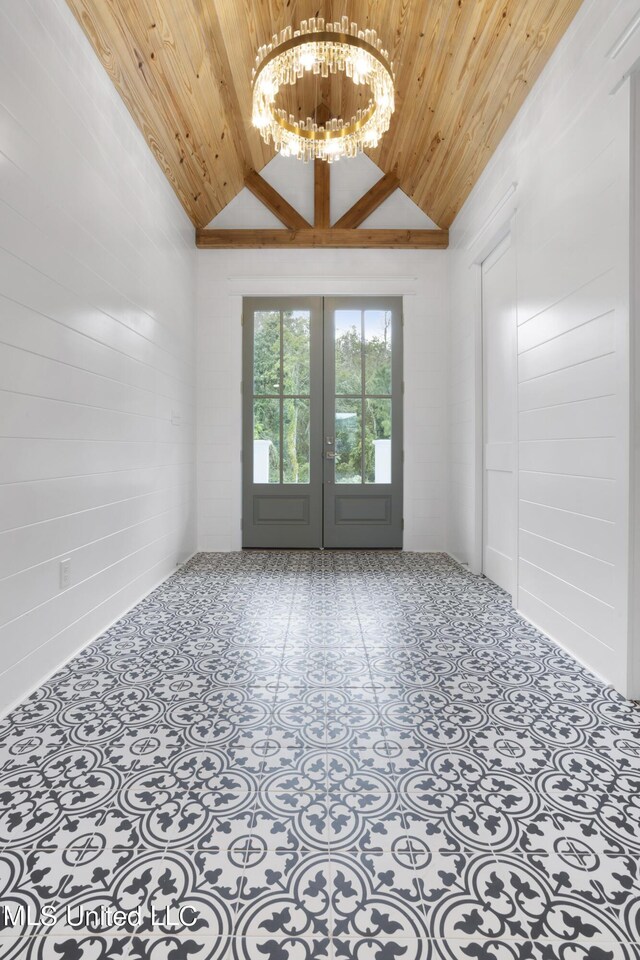 spare room featuring an inviting chandelier, wood ceiling, vaulted ceiling, and french doors