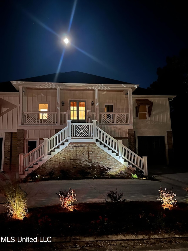 view of front of house with a porch, board and batten siding, and stairway