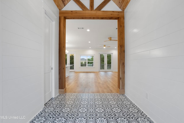 corridor with french doors, vaulted ceiling, and light hardwood / wood-style flooring