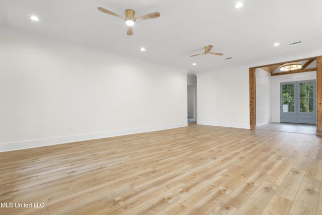 spare room with ornamental molding, visible vents, ceiling fan, baseboards, and light wood-style floors