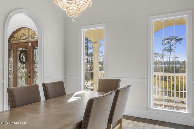 dining room with a wealth of natural light, wood finished floors, and a notable chandelier